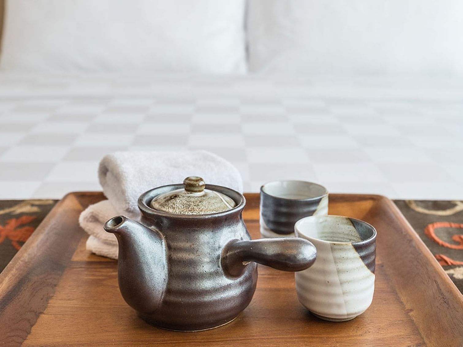 Tea set served on a bed featuring room service at LK Cikarang Hotel & Residences