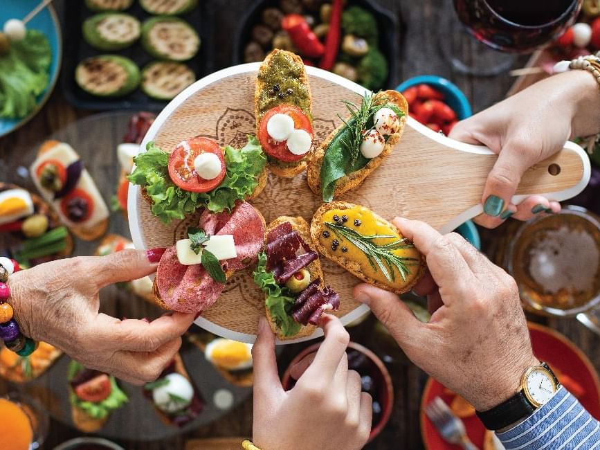 Close-up of people reaching out for variety of toppings on toast at Saujana Hotel Kuala Lumpur