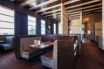 Chop Steakhouse & Bar with wooden booths and ambient lighting at Sandman Hotel & Suites Winnipeg Airport