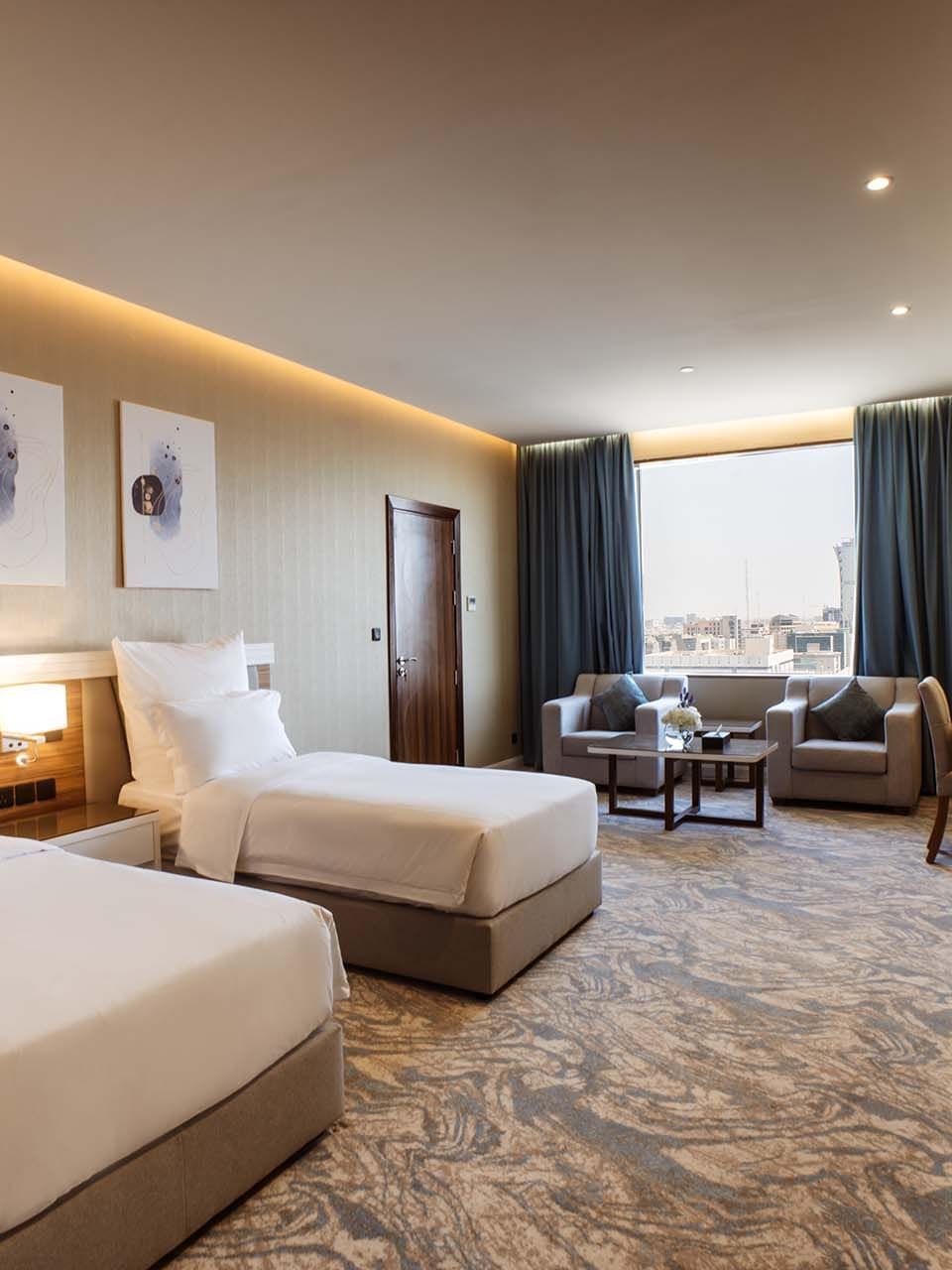 Superior King / Queen Room features Twin beds in a suite by a sitting area at Cantonal Hotel by Warwick Riyadh