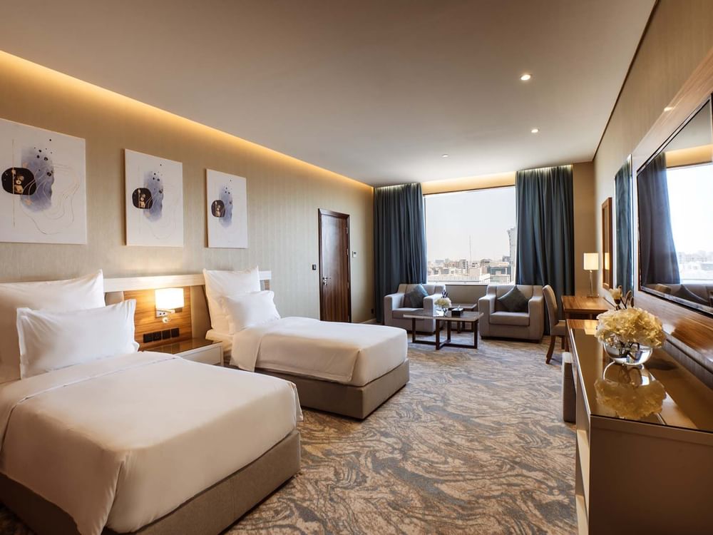 Superior King / Queen Room features Twin beds in a suite by a sitting area at Cantonal Hotel by Warwick Riyadh