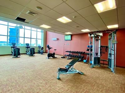 Modern gym with equipment and city view through the window at MARlNN Place Financial District, 5 star hotels in Panama