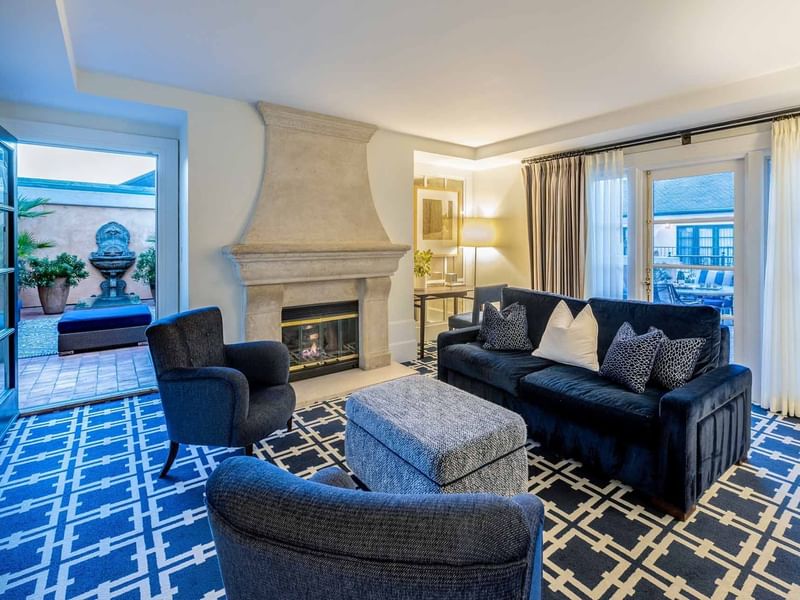 Living area with plush seating, carpeted floors, and a fireplace in the Penthouse at El Prado Hotel