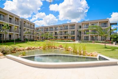 Exterior of The Hub Acunmeyda with outdoor pond surrounded by lush greenery