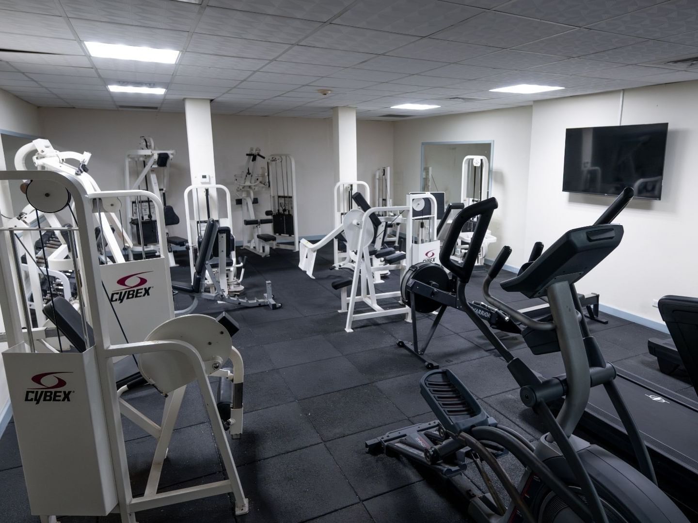 Multiple weight machines and treadmills in a gym at Savannah Beach Hotel.