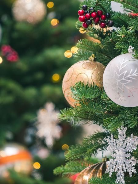 A close-up of a decorated Christmas tree featuring colorful ornaments at Warwick Hotels & Resorts