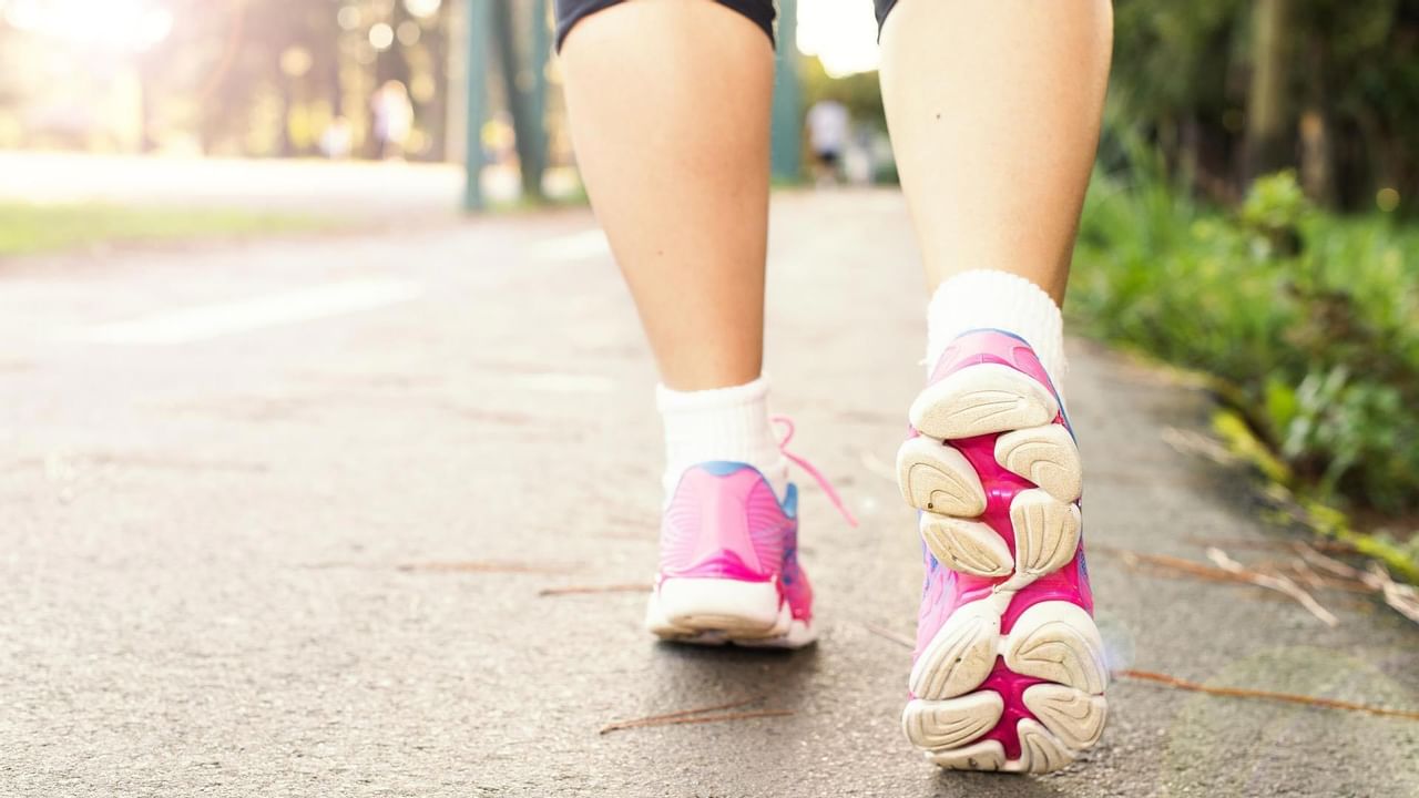 View of someone's pink shoes as they walk on a pathway