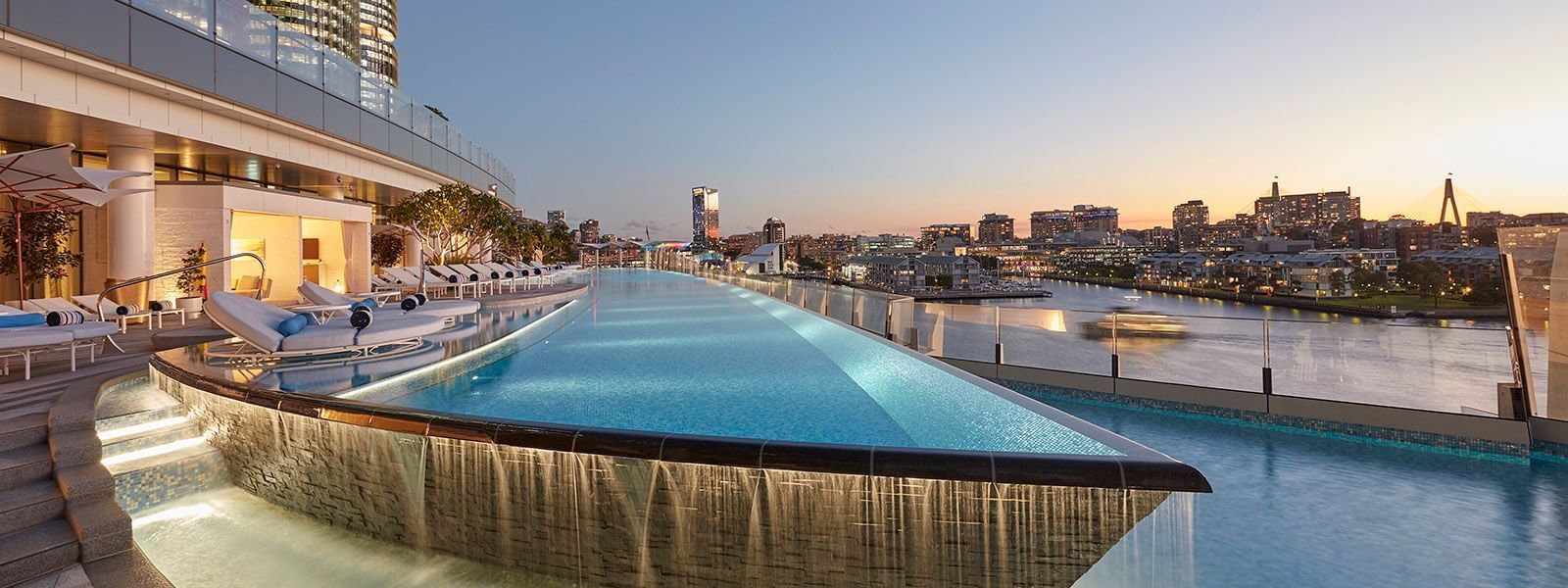Landscape view of an infinity pool with city view at Crown Hotels