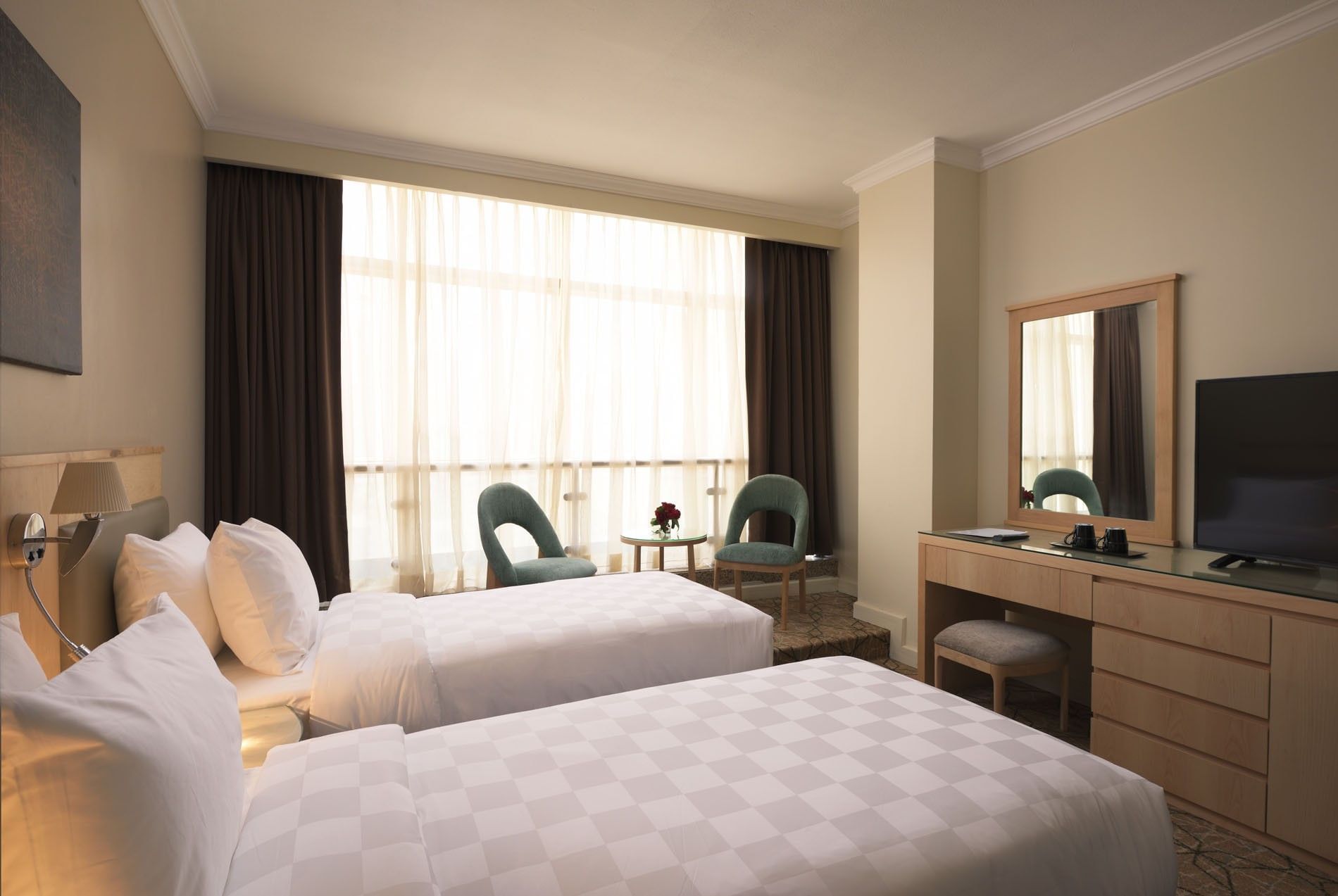 Standard Double Room featuring two beds facing large mirror and seating area at Saja Warwick Madinah