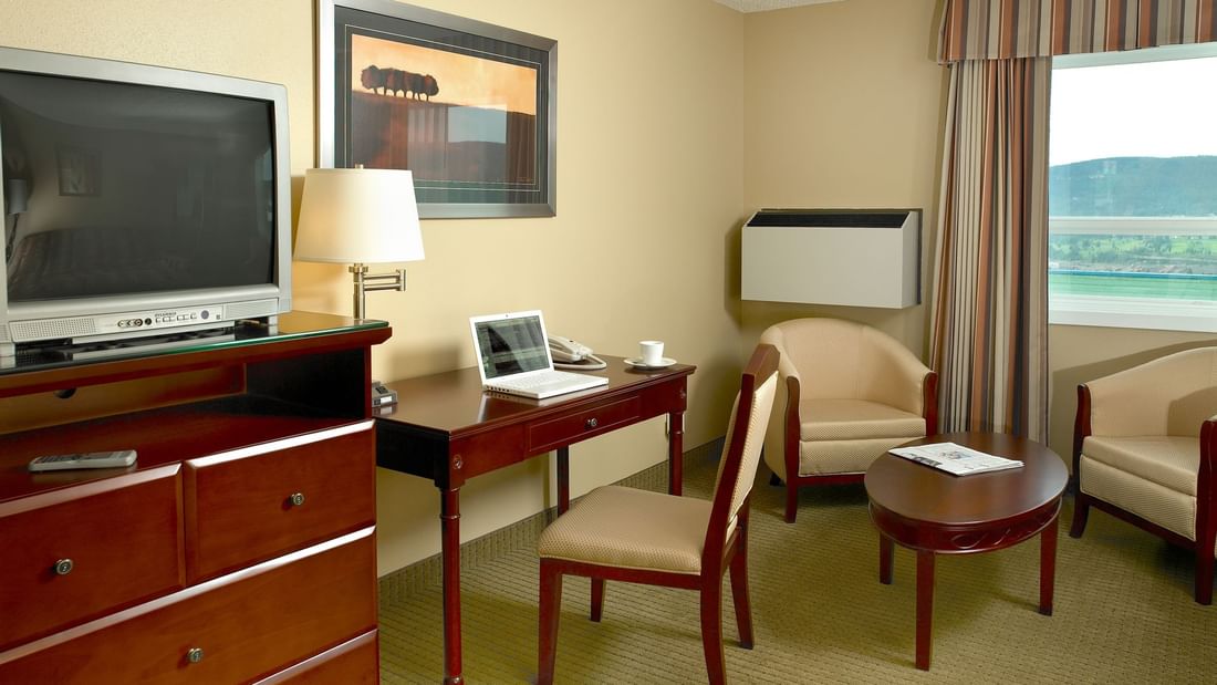 desk and TV in hotel room with window
