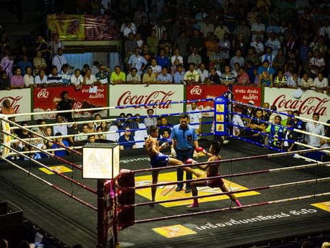 A Muay Thai match in progress at Lumpini Stadium