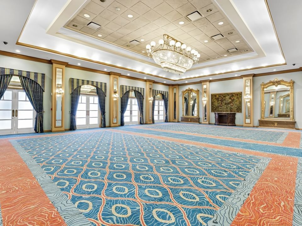 Luxury interior of the spacious Magnolia Ballroom with a chandelier & carpeted floors at Las Casitas Village