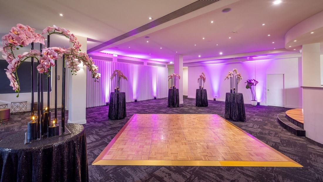 Elegantly decorated event room with floral arrangements and a dance floor at Mercure Gold Coast Resort in Carrara.