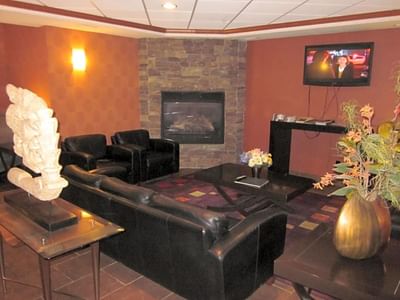 Interior of the lobby lounge area with a fireplace at Franklin Suite Hotel, Fort Mcmurray Hotels Downtown