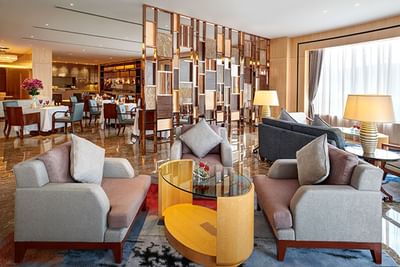 Lounge area featuring modern furniture & carpeted floors at One World Hotel