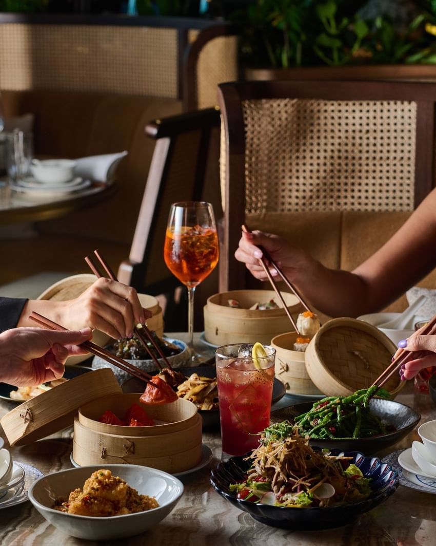 Diners with chopsticks and wine enjoy an Asian meal at Paradox Vancouver