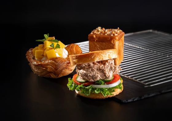 Tuna salad sandwich and fruit pastry on a tray at Carlton Hotel Bangkok Sukhumvit