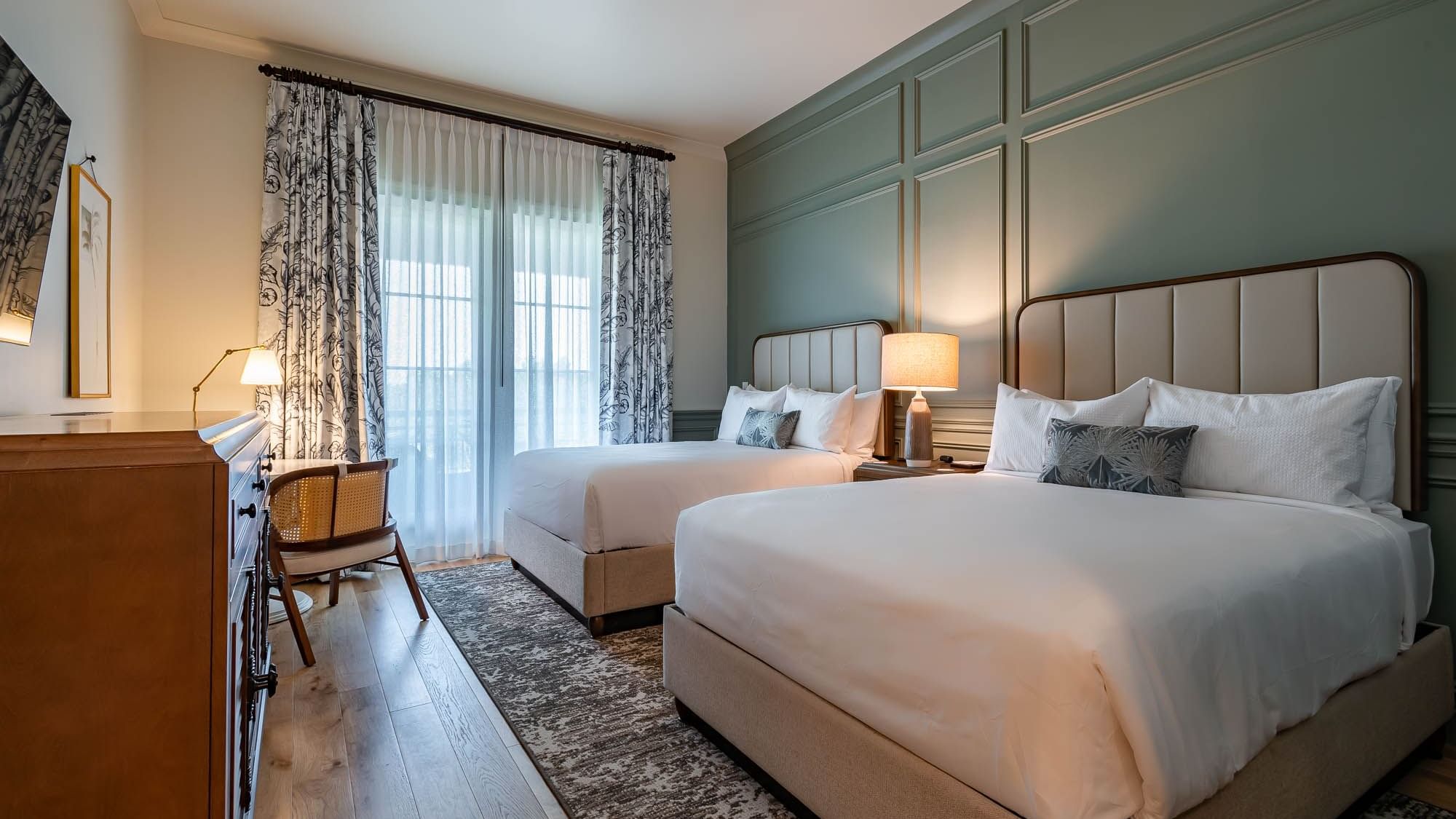 Twin beds by the drawers & chair in Golf View Queen Room With Balcony at Camp Creek Inn