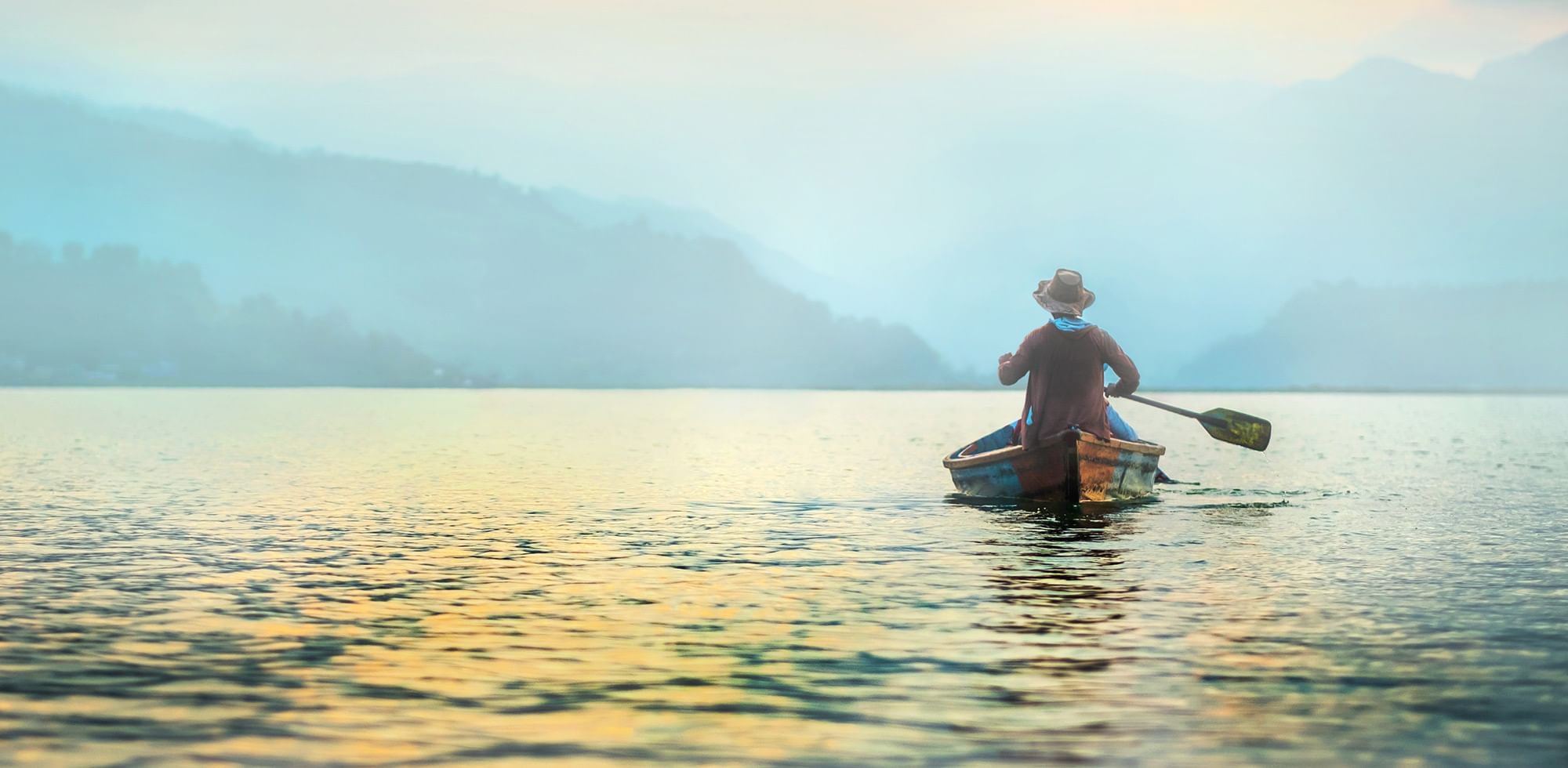 Man in a canoe with paddle in his right hand