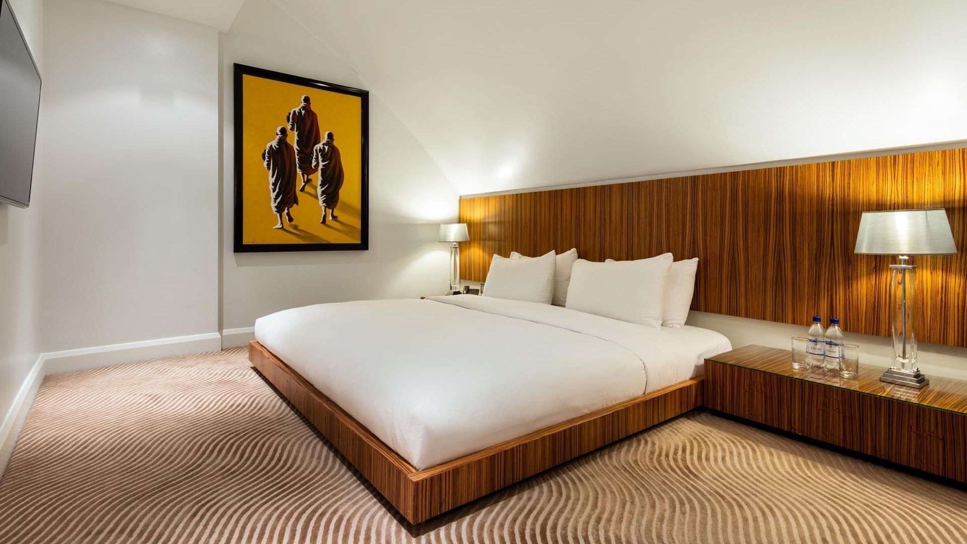Minimalist Duplex Suite at The May Fair Hotel London with a king-sized bed flanked by wooden nightstands