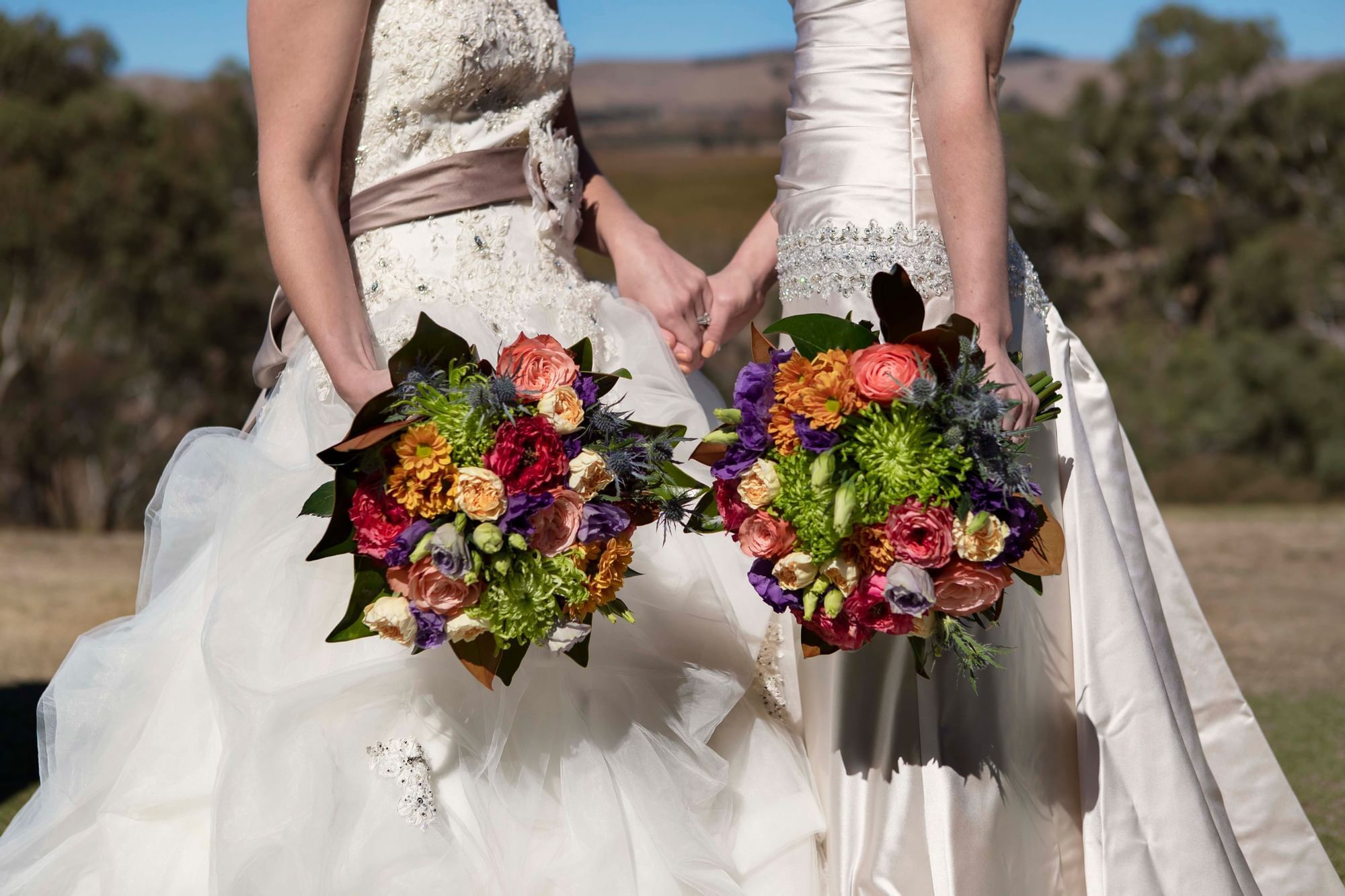 2 Brides holding bouquets & posing at Novotel Barossa