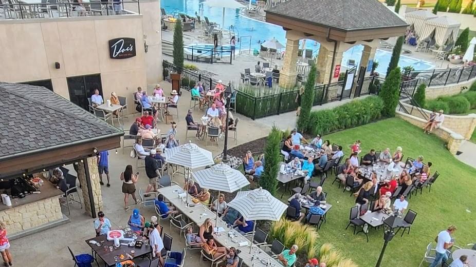 Vibrant poolside bar at Doc's lower patio with diners at umbrella tables and sunbathers, at Shangri-La Monkey Island