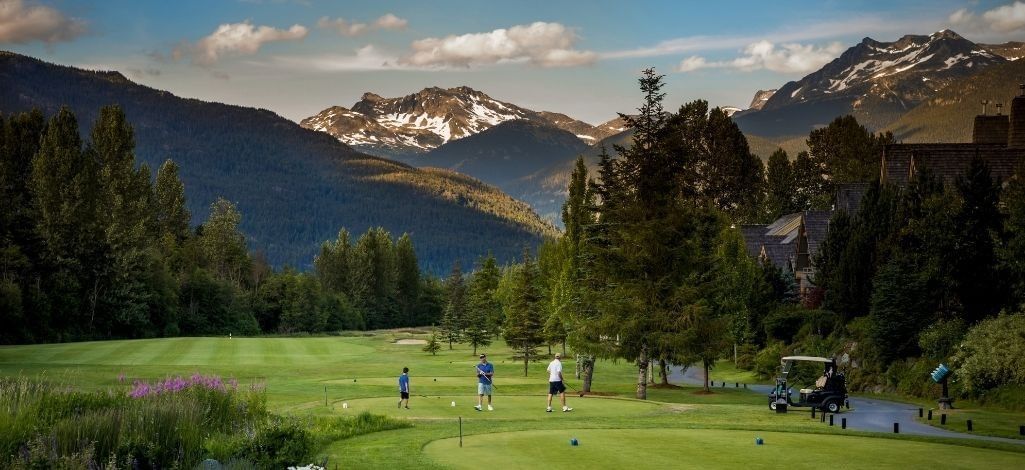 Golfers prepare to tee off at Nicklaus North Golf Course with mountain views in the background.