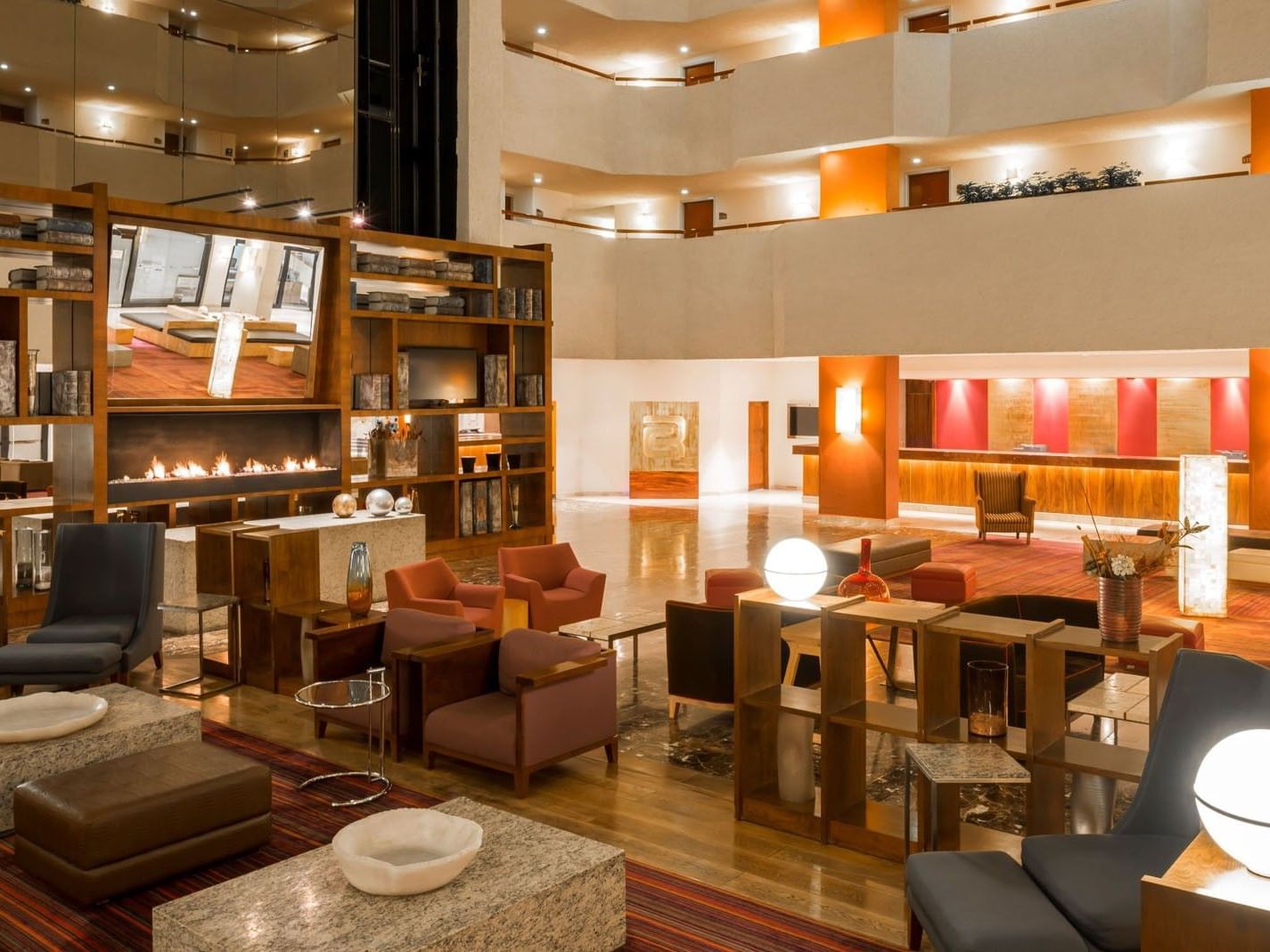 Lobby Bar lounge with modern armchairs and a decorative fireplace at Camino Real Aeropuerto Mexico