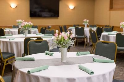 Round tables set with mint green napkins and flowers in the meeting room at The Boulevard Inn & Bistro