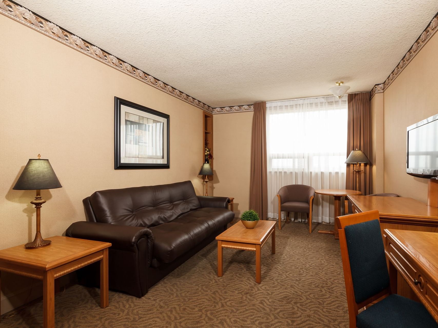 Living area with sofas and work area in Business Suite at The Glenmore Inn & Convention Centre