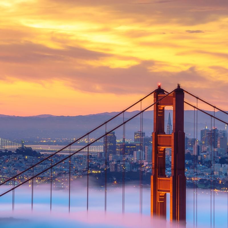 Golden Gate Bridge with city view under evening sky near Warwick Melrose Dallas