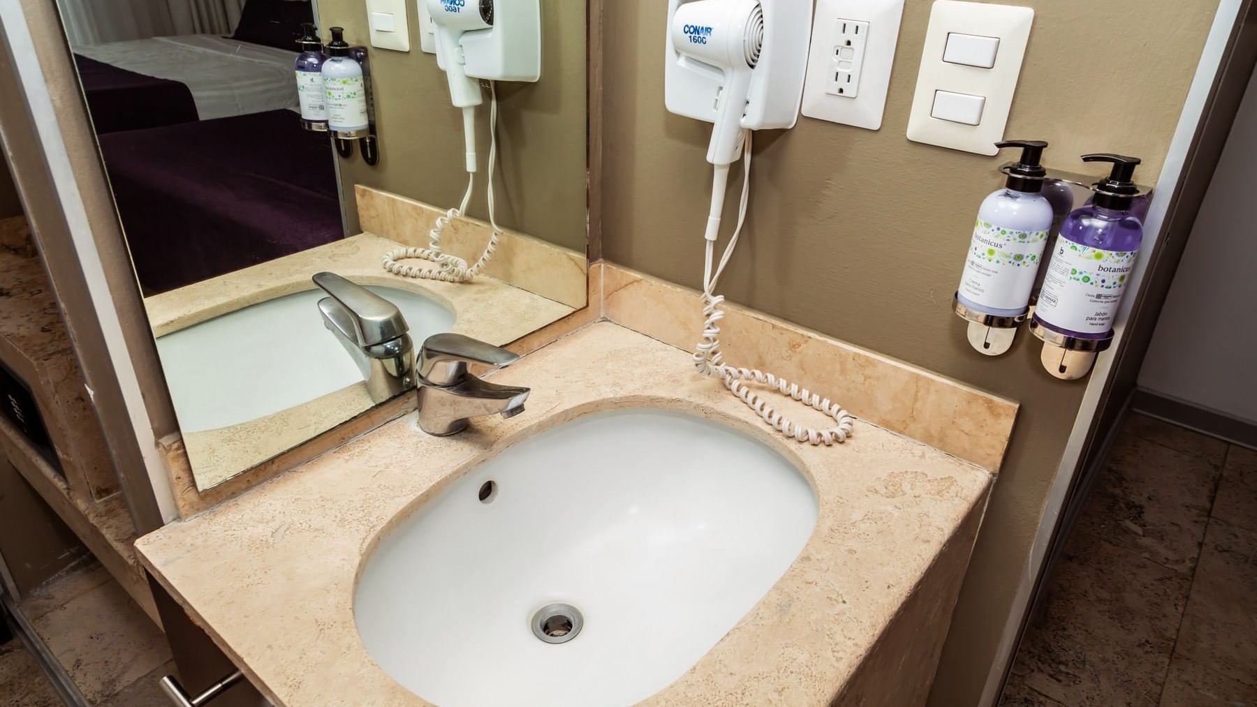 Wash basin, soap dispensers, hair dryer & silver faucet in a room at Gamma Puebla Senorial Centro