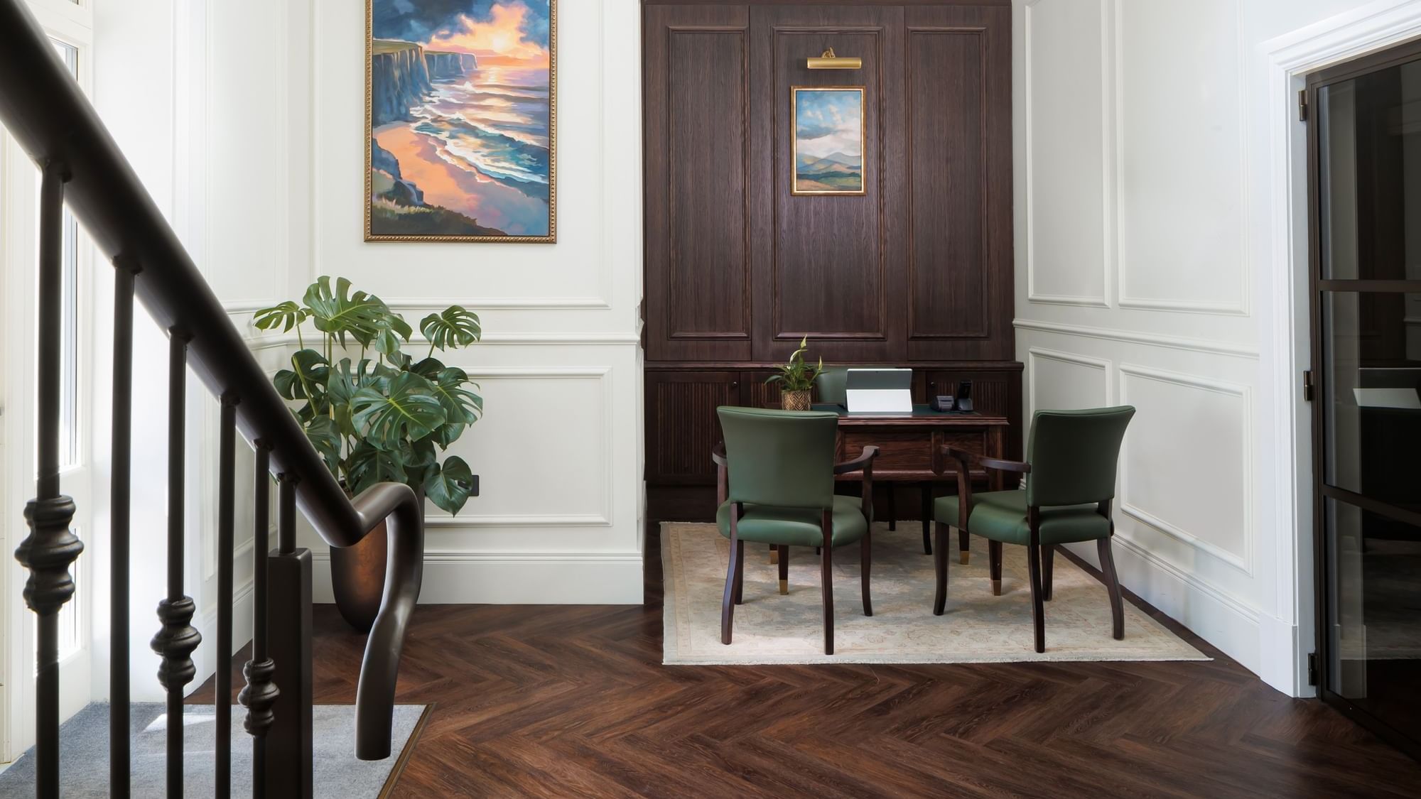 Stylish private office with dark wood paneling and green chairs, at Dunluce Lodge, featuring a desk and artwork