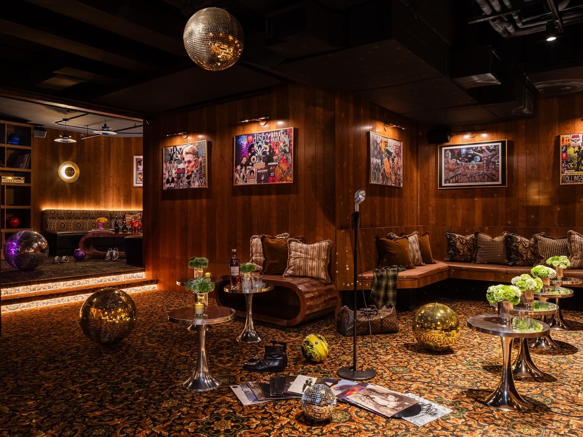 Dimes event room with wood-paneled walls, disco ball, vintage music posters, and lounge seating at Gansevoort Meatpacking NYC.