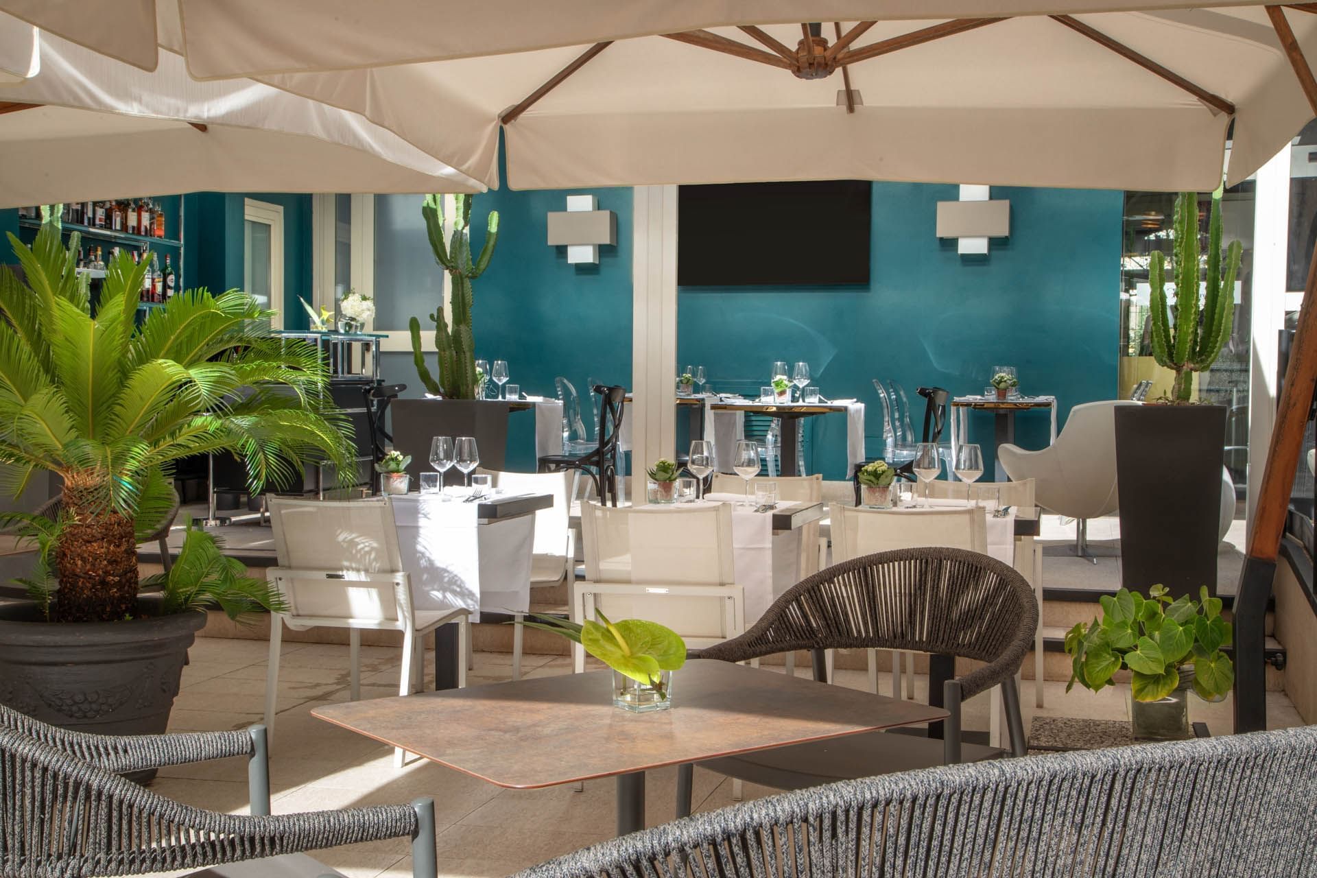 Elegant Guardian Dehors outdoor dining at The Guardian Hotel with modern furniture and a vibrant blue wall