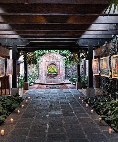 Sendero de piedra iluminado con velas y obras de arte en macetas en los mejores hoteles del Lago Atitlán, Porta Hotel Antigua