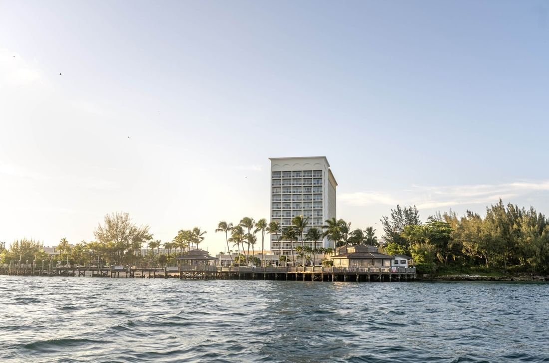 Waterfront view of Warwick Paradise Island hotel with palm trees and a clear sky