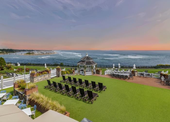Outdoor patio with green artificial grass and lounge chairs overlooking the ocean at Ogunquit Collection