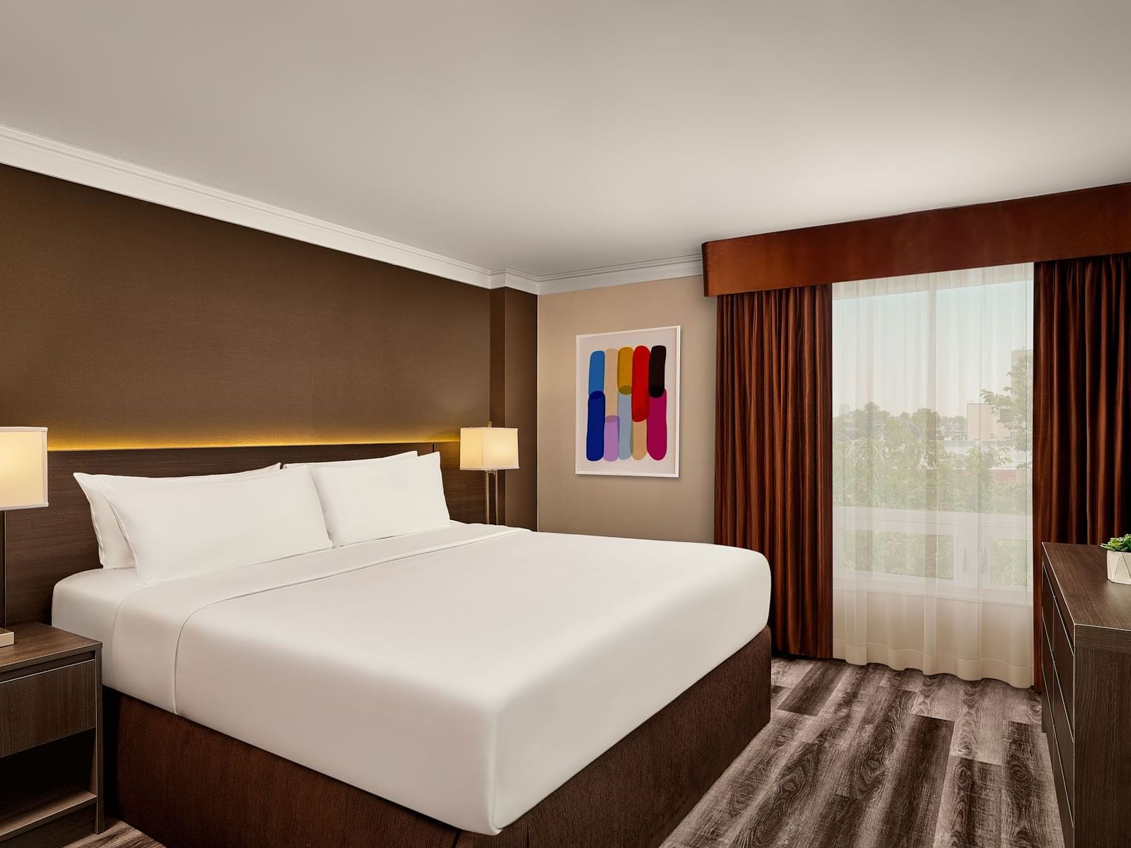 Reimagined King Suite with a king bed, modern art, and dark wood furniture at the Varscona Hotel on Whyte