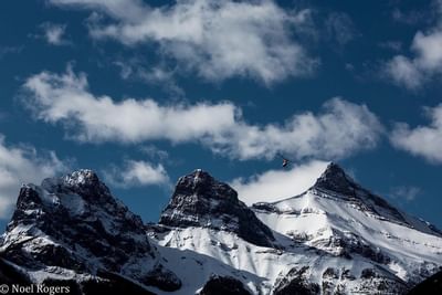 Distant view of mountain ranges in Banff National Park under a partly cloudy blue sky near Blackstone Mountain Lodge
