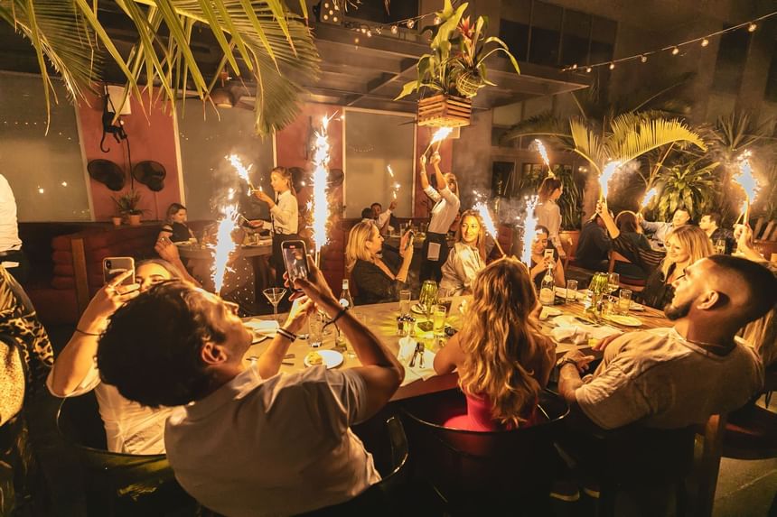 A group at a garden dinner with sparklers at South Beach Hotel