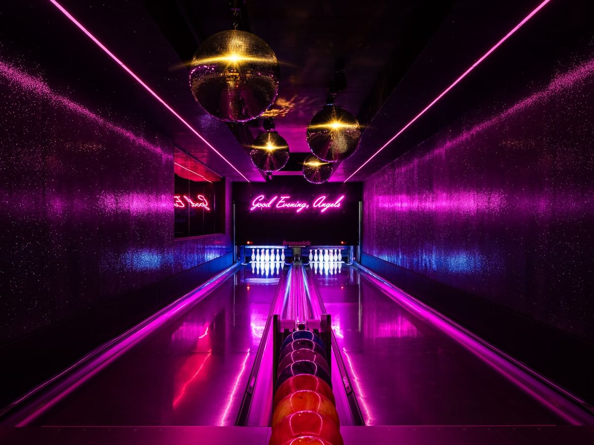 Dimes bowling alley with vibrant pink and purple neon lighting and disco balls at Gansevoort Meatpacking NYC - NEW