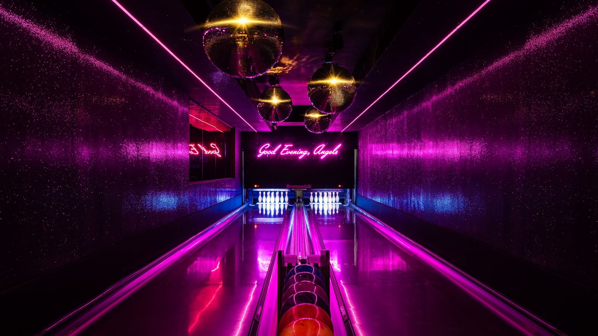 Dimes bowling alley with vibrant pink and purple neon lighting and disco balls at Gansevoort Meatpacking NYC - NEW