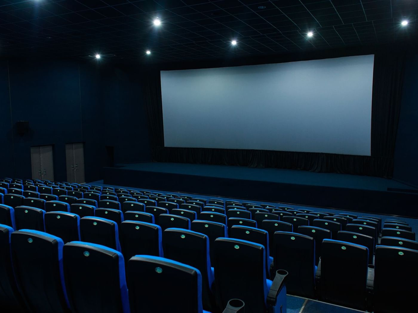 Blue themed cinema with huge screen and seating near Grand Fiesta Americana
