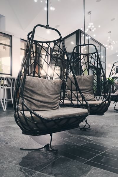Rattan hanging egg chairs in lobby area, Aava Whistler Hotel