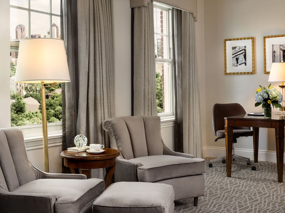Deluxe King with Grey velvet armchairs by a round side table under a tall gold floor lamp at Warwick Melrose Dallas