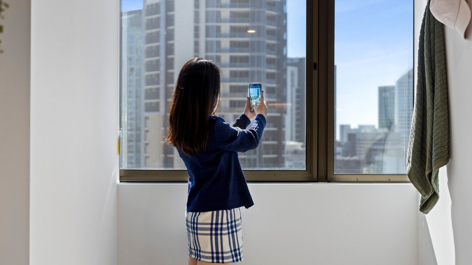 Woman taking a photo with her smartphone at UniLodge Brisbane City.