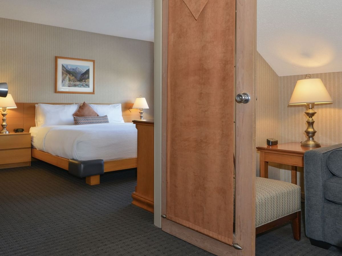 Spacious hotel suite with a king bed, elegant decor, and sofa bed.