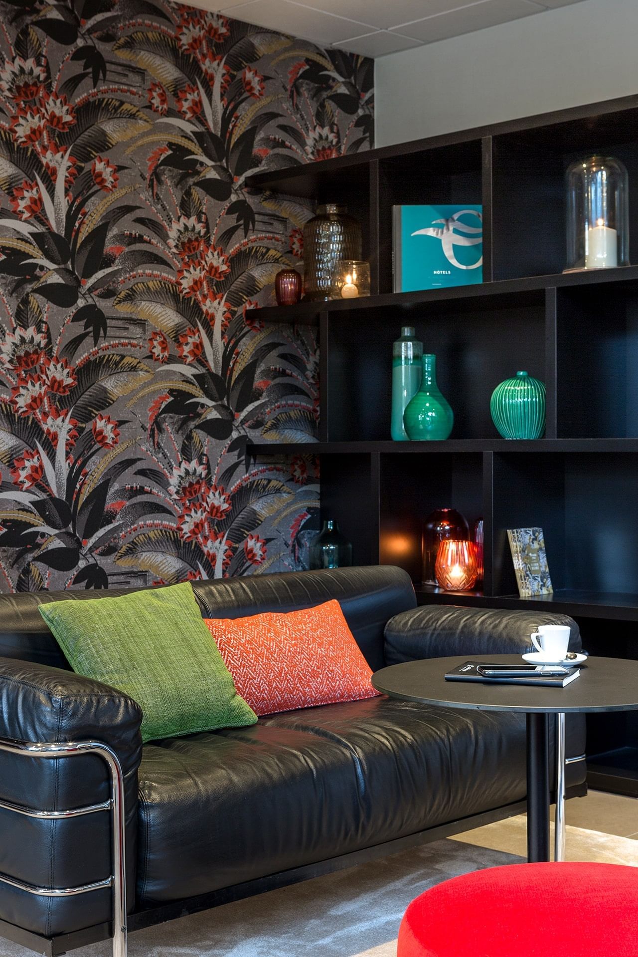 Lobby lounge area by a shelf at Oceania Nantes Aéroport