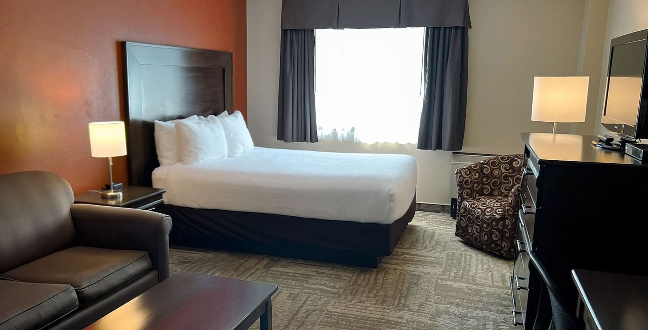 Hotel room with bed, couch, table, and TV